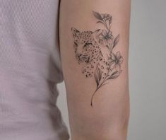 a woman's arm with a black and white tattoo of a cheetah