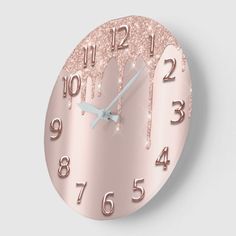 a rose gold clock with hearts and numbers on the face that is covered in icing