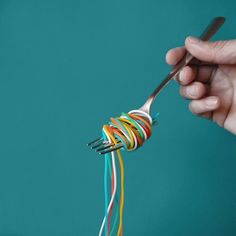 a person is holding a fork with wires in it and they are all connected together