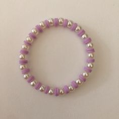 a purple and white beaded bracelet with silver beads