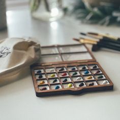 an assortment of paints and brushes sitting on a table