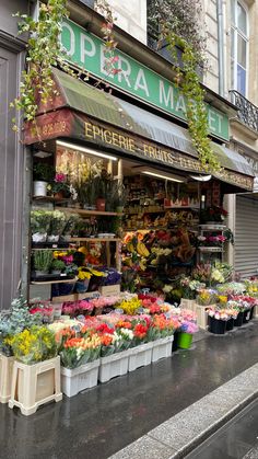 a flower shop with many different flowers on the front and side of it's storefront