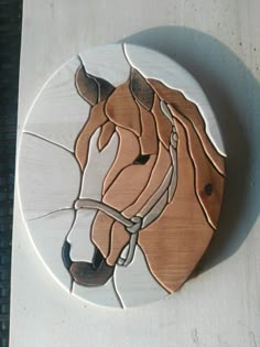 a wooden horse head is shown on a white plate with brown and black lines around it