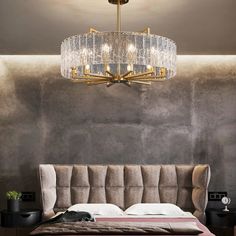 a chandelier hanging from the ceiling over a bed in a room with grey walls