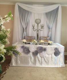 the table is set up for a wedding reception with flowers and candles on it's side