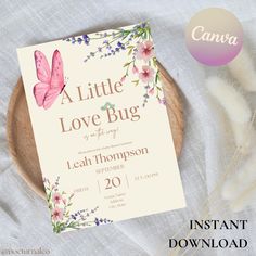 a little love bug baby shower is displayed on a plate with feathers and flowers in the background