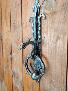 a metal door handle on the side of a wooden wall with an animal design attached to it