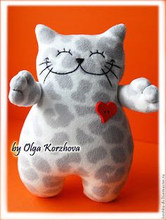 a white cat stuffed animal with a red heart on it's chest and paws