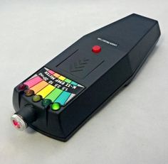 a multicolored electronic device sitting on top of a white surface with red and green buttons