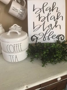 there is a sign that says coffee and tea on the counter next to some potted plants