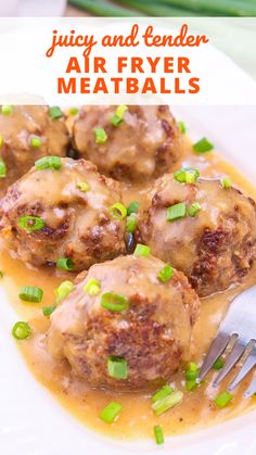 meatballs covered in gravy and green onions on a white plate with a fork