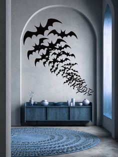 a living room with a blue rug and wall decal in the shape of bats