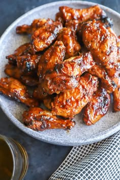 a white plate topped with chicken wings covered in bbq sauce