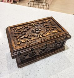 a wooden box sitting on top of a white counter next to a dining room table