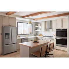 a modern kitchen with stainless steel appliances and wood flooring, along with white cabinets