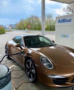 a brown sports car being charged at an electric charging station