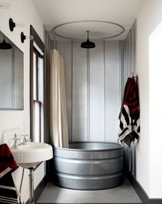 a bathroom with a tub, sink and mirror