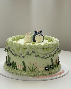 a cake decorated with green frosting and animals on top