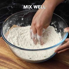 someone is mixing flour in a bowl on a wooden table with the words mix well above it