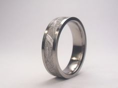 a wedding ring with an etched design on the outside and inside, is shown against a white background