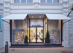 a chanel storefront with mannequins on display in the front window