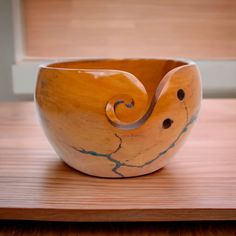 a wooden bowl sitting on top of a wooden table