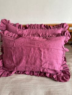 two pillows with ruffled edges on a bed