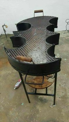 an outdoor bbq grill sitting on top of a cement floor next to a white wall