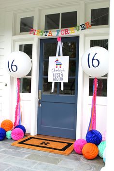 balloons and streamers are on the front door of a house for a birthday party