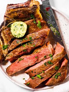 a plate with steak, potatoes and garnishes on it next to a knife