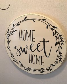 a sign that says home sweet home hanging on the wall next to a toilet paper dispenser