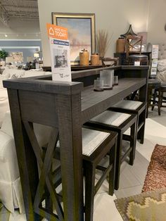 a table with stools and a sign on it in a room filled with furniture