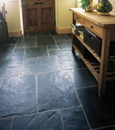 a kitchen with stone flooring and wooden cabinets