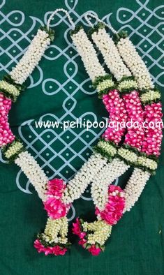 some flowers are arranged in the shape of a wreath on a green cloth with white and pink trimmings