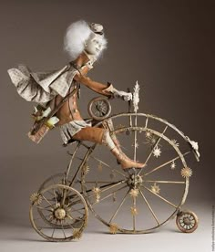 an old fashioned bicycle made out of wood and metal with a white hair woman riding on it