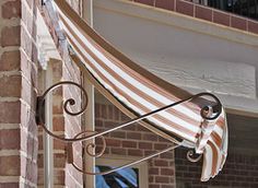 an awning on the side of a building with brick and white trim around it