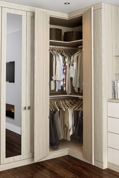 an open closet with clothes hanging in it