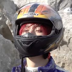 a woman with red hair wearing a motorcycle helmet