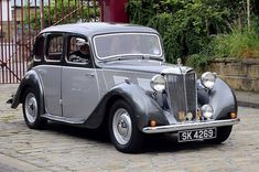 an old car is parked on the street