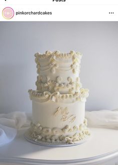 a three tiered white wedding cake sitting on top of a table next to a pillow