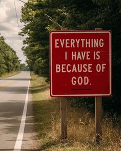 a red sign that says everything i have is because of god on the side of the road