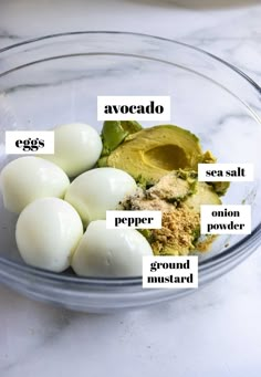 ingredients for avocado in a glass bowl on a marble counter top with labels