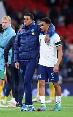 two soccer players standing next to each other on a field