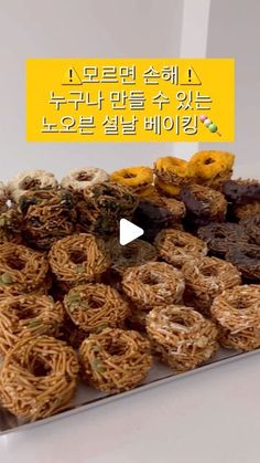 a tray filled with lots of different kinds of donuts on top of a table