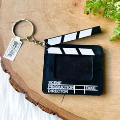 a black and white clapper keychain sitting on top of a piece of wood