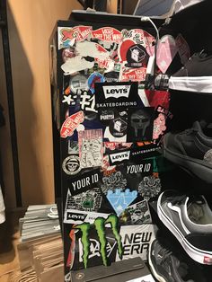 there are many stickers on the back of a suitcase that is full of shoes