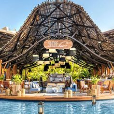 the inside of a restaurant with a pool and lounge chairs in it's center