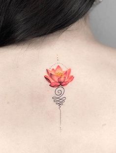 a woman's upper back tattoo with a pink flower on her left side ribcage