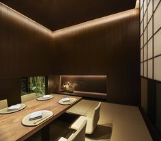 a table with plates and place settings on it in a room that has wood paneling