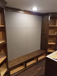 a room with wooden shelves and shelving in the corner, along with an empty bin